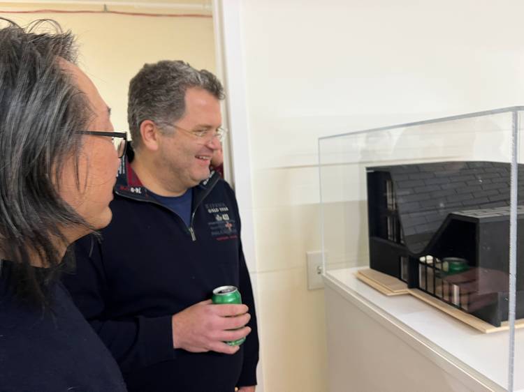 Attendees atAIA's Body of Work event view an architectural rendering, 'Roofscape Haus.'